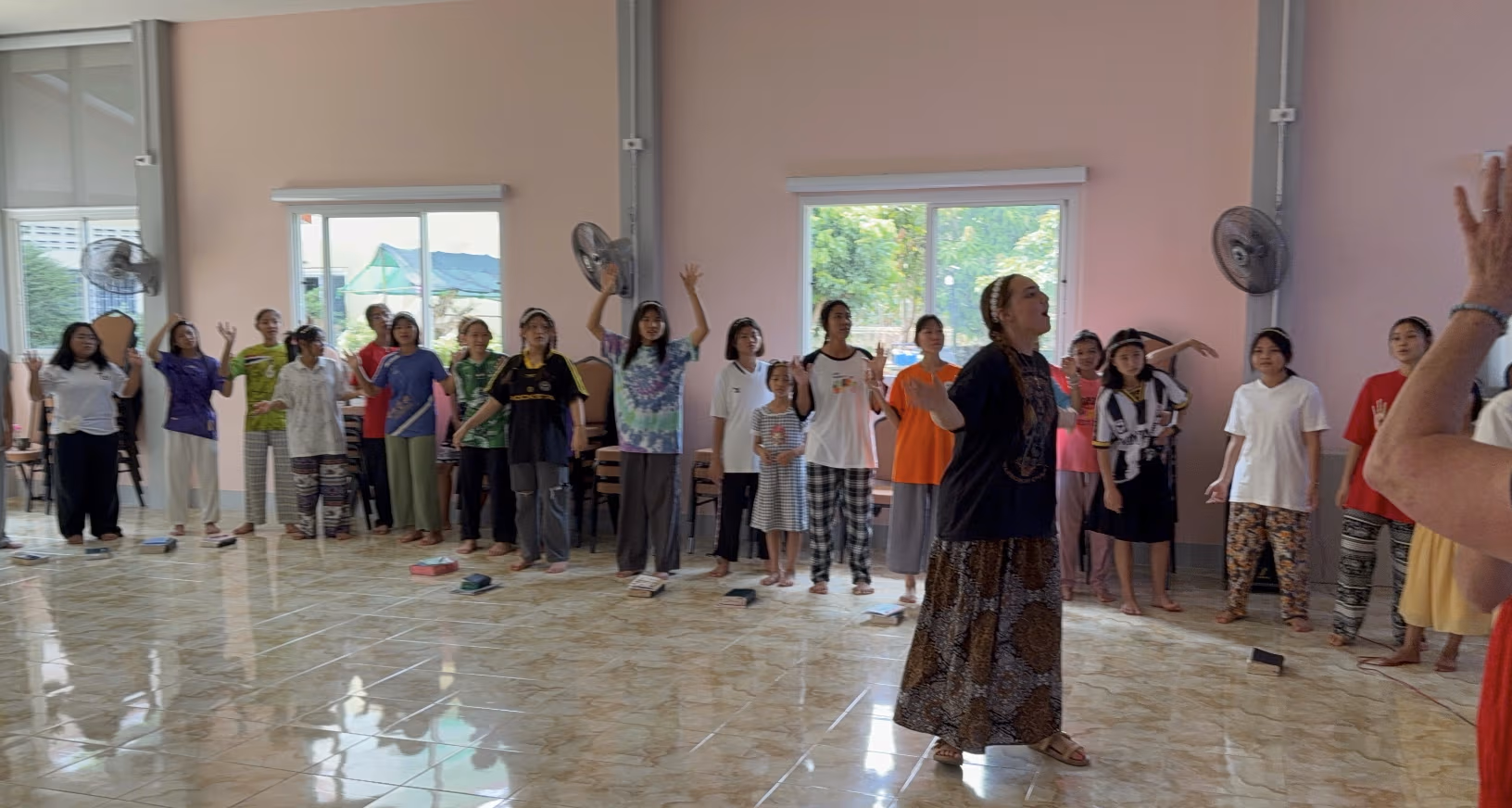 Joelle and the Faith House girls singing together during morning worship